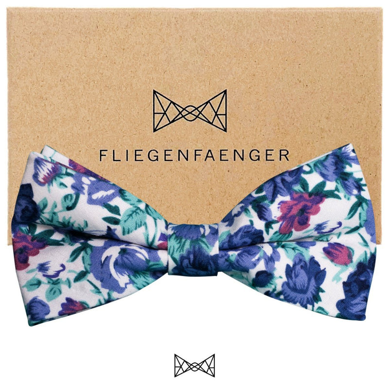 Fliege mit blauem Blumenmuster mit grünen und roten Akzenten auf weißem Fond. Handgefertigt aus Bielefeld von Fliegenfänger. Jetzt bei GOKAL - kauf lokal