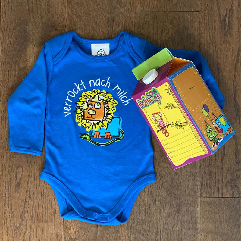 Geschenkbox für Babys. Blauer Body mit lustigem Löwenmotiv "verrückt nach Milch" und einer Erinnerungsbox in Form einer Milchtüte. Jetzt bei GOKAL kauf lokal